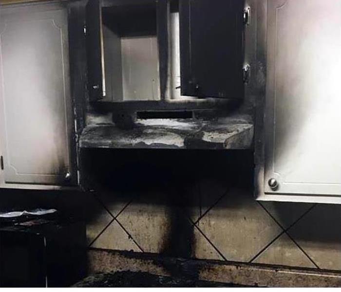 Kitchen covered in soot and smoke damage after a fire