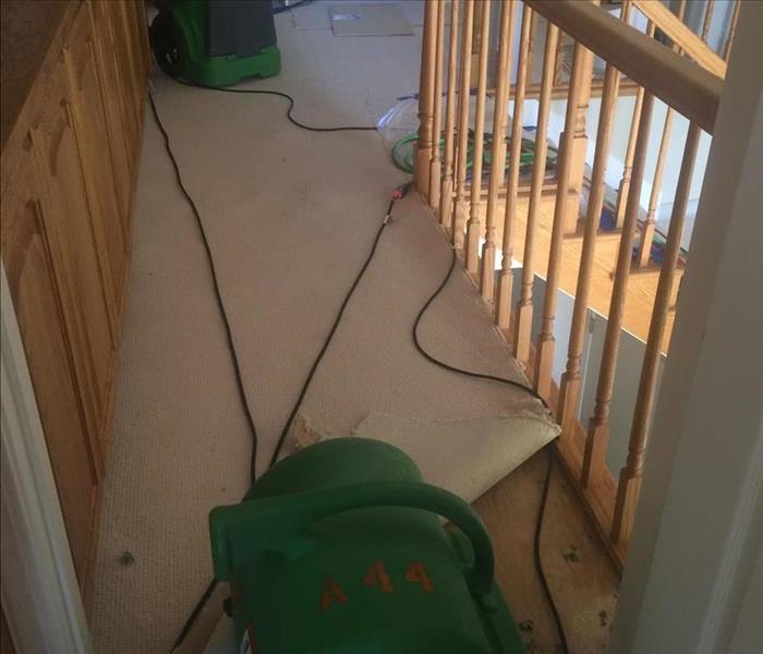 SERVPRO equipment on the floor with carpet lifted, on the second floor of a home. 