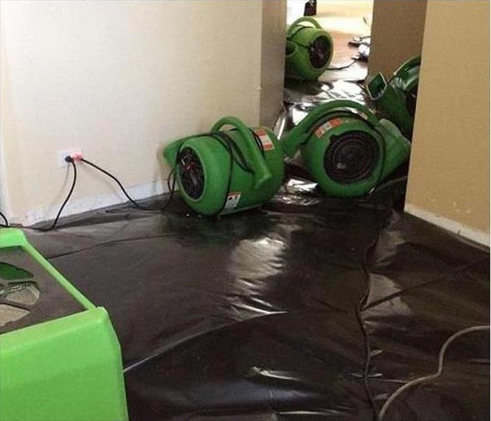 Air movers working in a room in this house drying it after a water damage disaster 